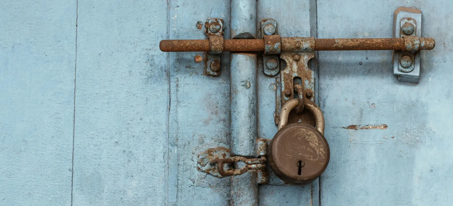 A rusted lock at at an old wooden door