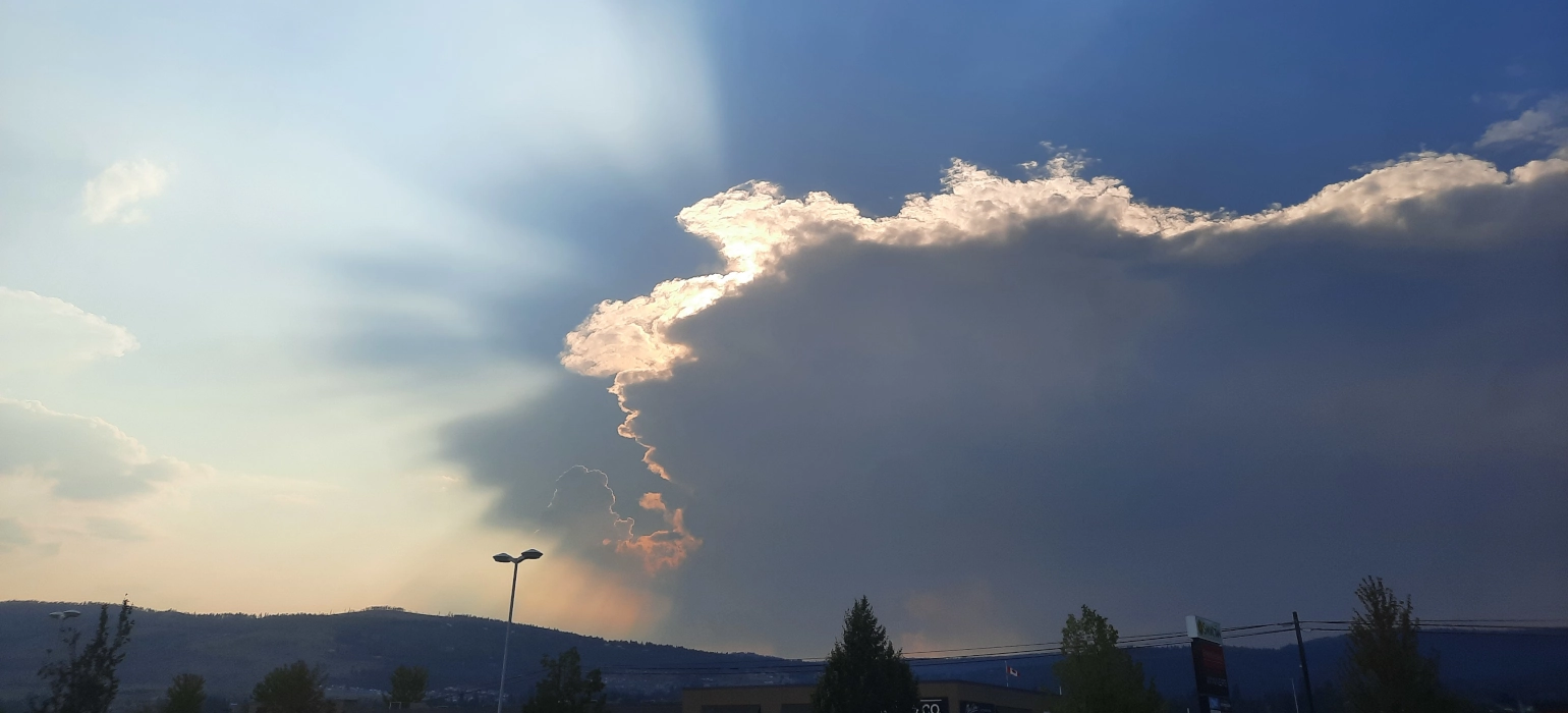 The sun shines brightly behind a cloud, casting a half halo of rays to the left of the image, and leaving the right of the image quite dim.