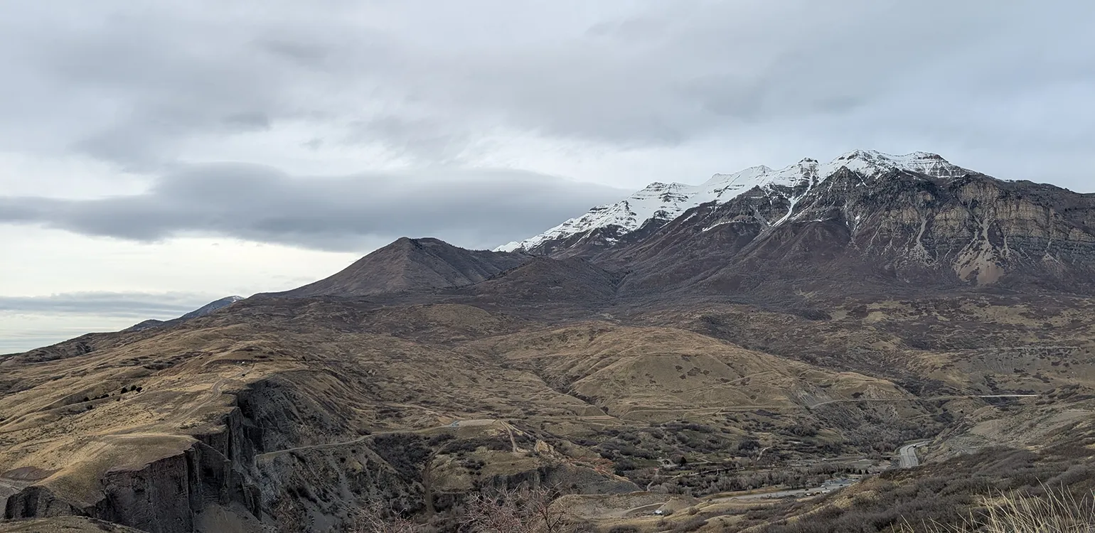 A snowy mountain towers over a clouded valley